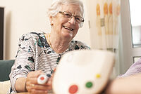Hausnotrufgerät wird für Seniorin erklärt