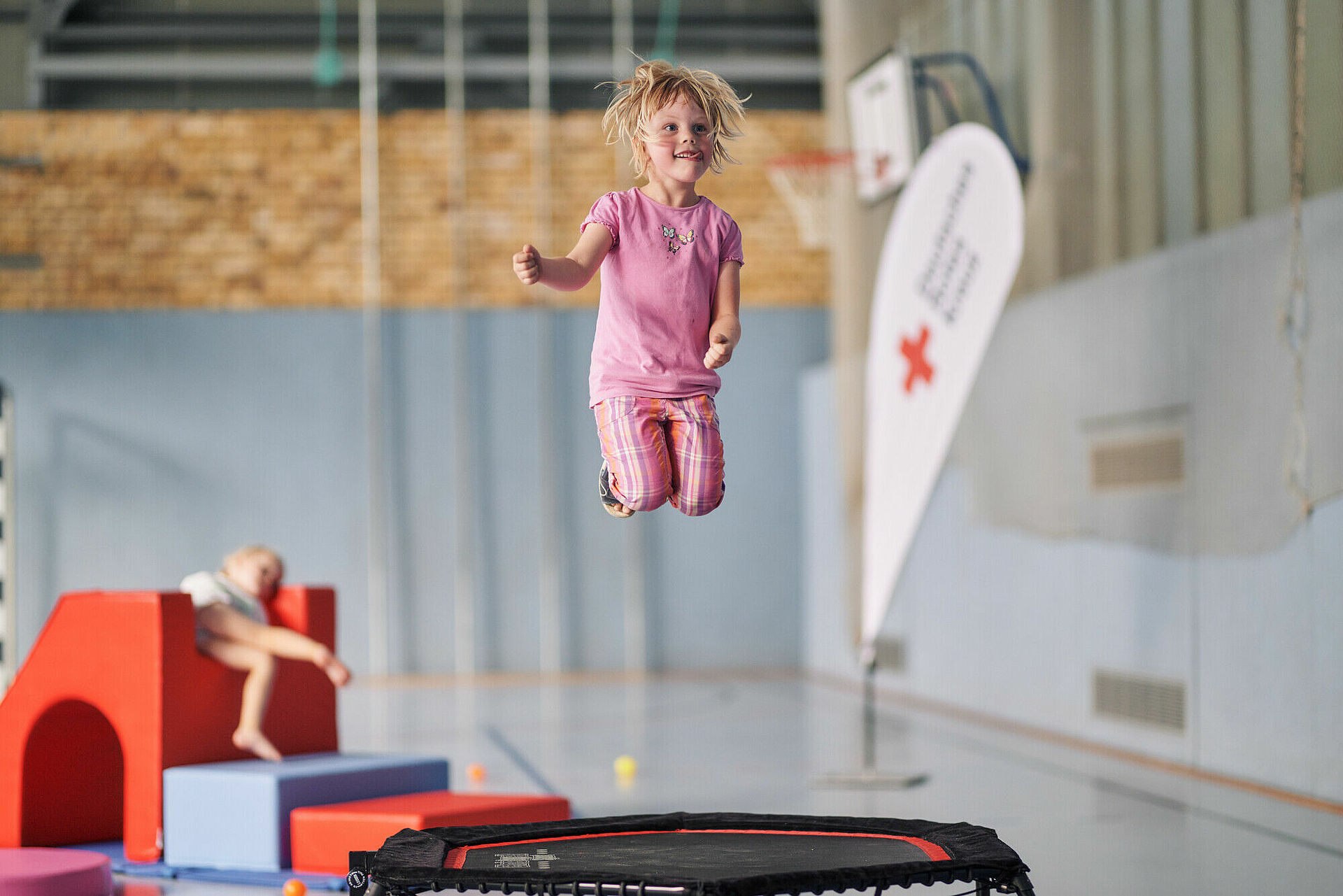 Mädchen springt Trampolin in einer Sporthalle